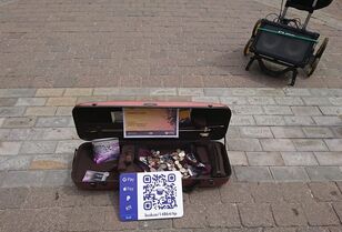 Buskers amplifier and violin case with coins, cds, and qr code